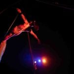 Return to the Source: Woman doing aerial dance performance photographed from a low angle.